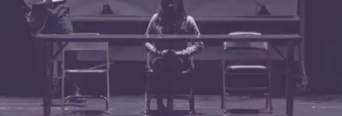 Una mujer sentada en una silla de interrogatorio